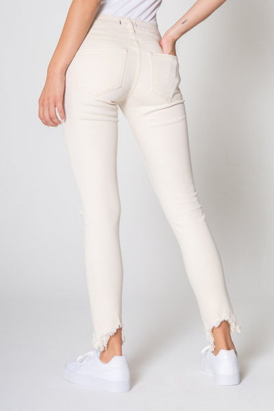 Comfortable mid rise white skinny jeans with rips in the knees and cut out at the bottom. 
